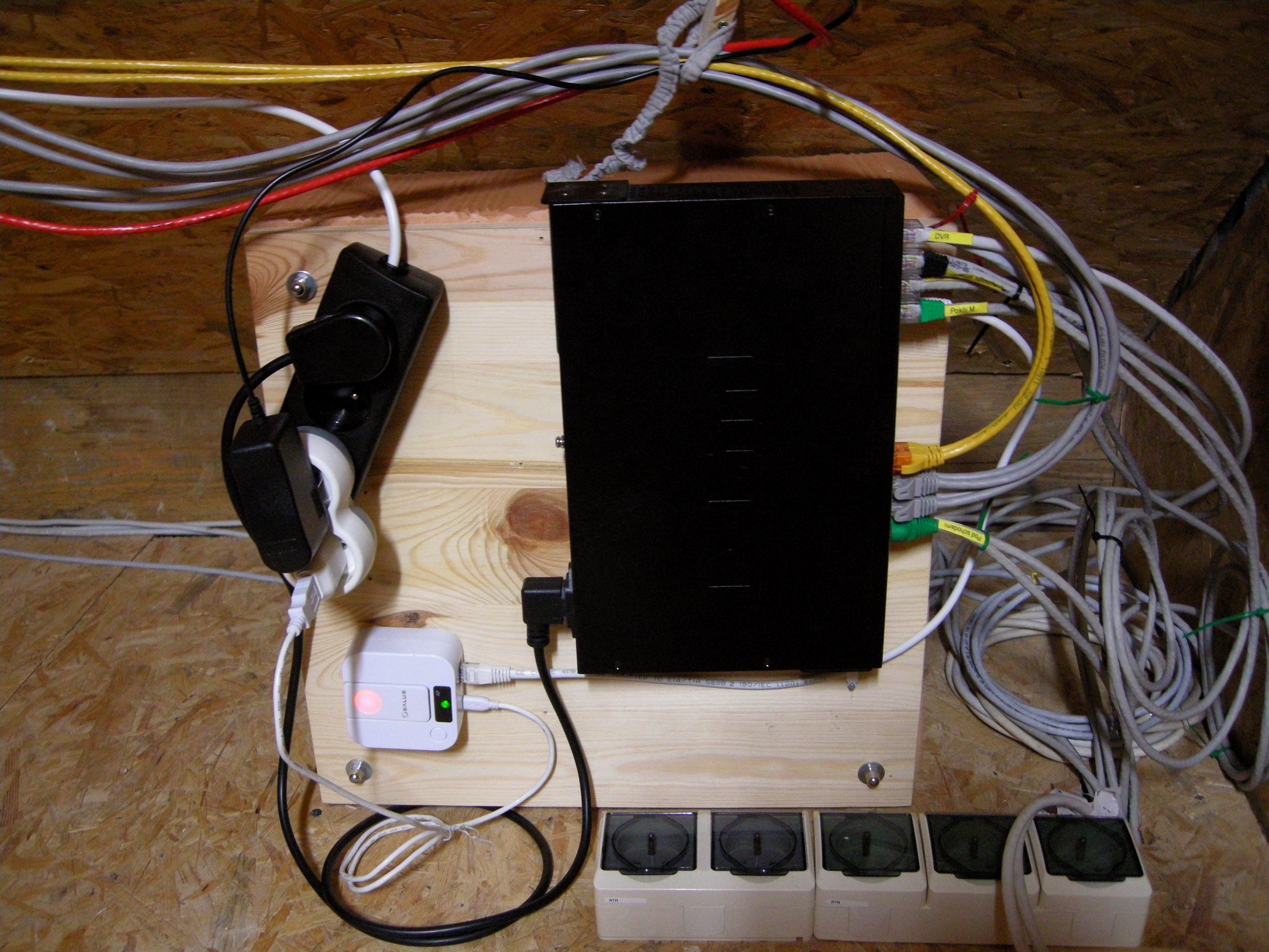 we observe an extension, cable leaving stage right, the bit with the sockets screwed into the same basal platin what holds a network switch; this appears to be the only source of power, as the floor sockets are all unoccupied